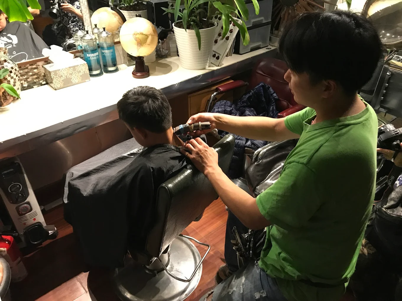 Edison, the owner, cutting a client's hair at Edison Hair Salon